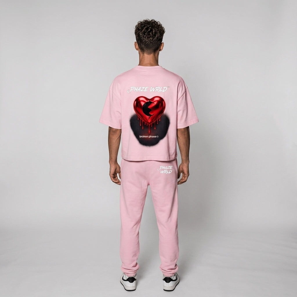 Back view of a premium baby pink boxy cropped streetwear t-shirt featuring a metallic red dripping heart graphic and white "PHAZE WRLD" branding.