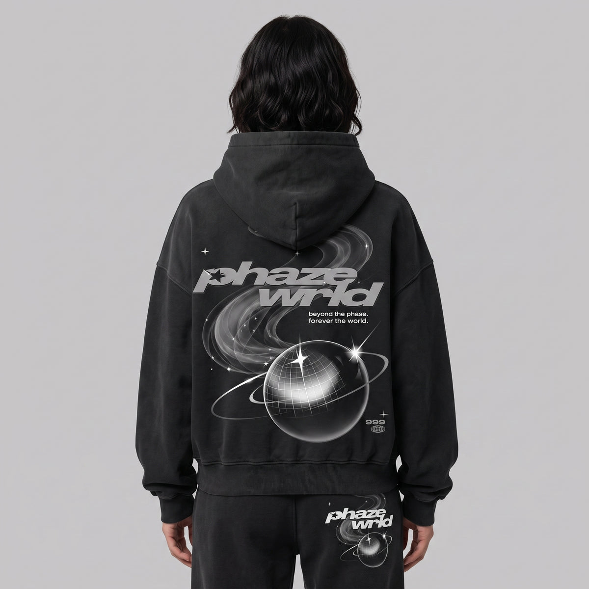 Model from behind wearing the dark grey Beyond the Phaze 999 hoodie with its large white planet back graphic.