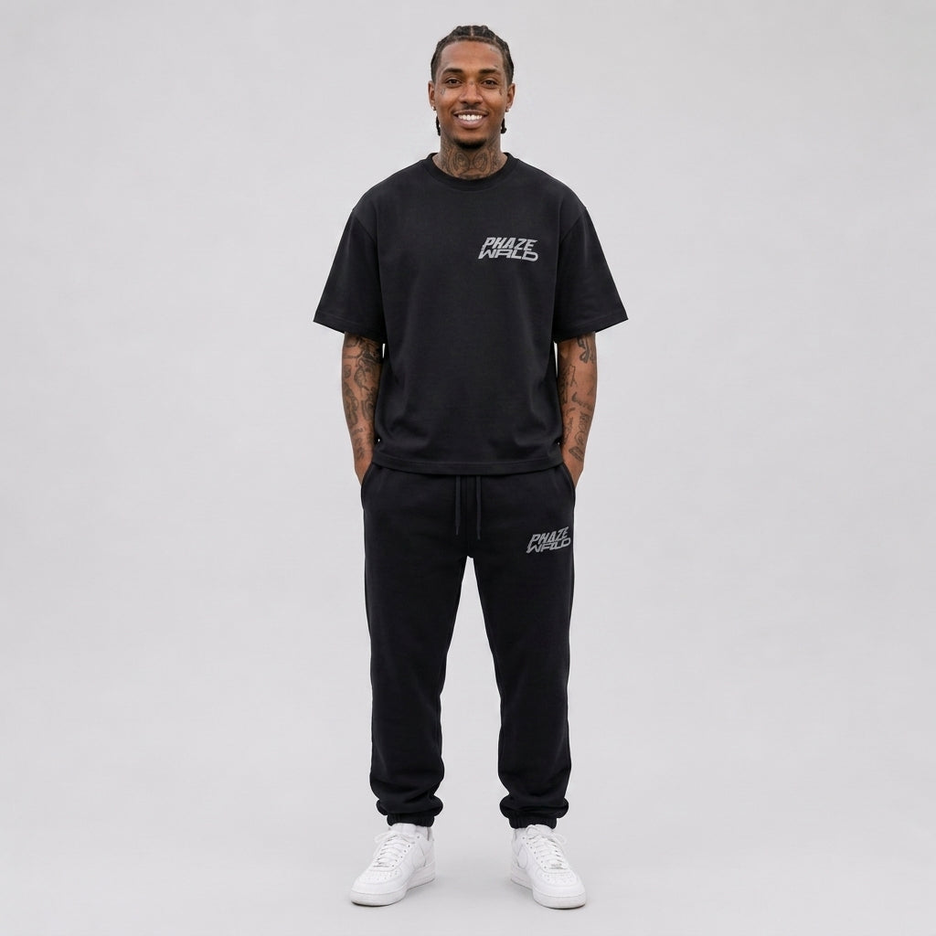 A premium heavyweight black oversized streetwear t-shirt featuring a minimalist silver Phaze Wrld graphic logo on the left chest.