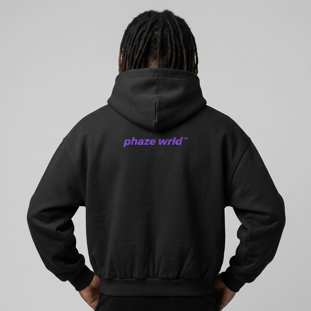 Back view of a premium black oversized streetwear hoodie featuring a vibrant purple "phaze wrld" logo graphic on the upper back.