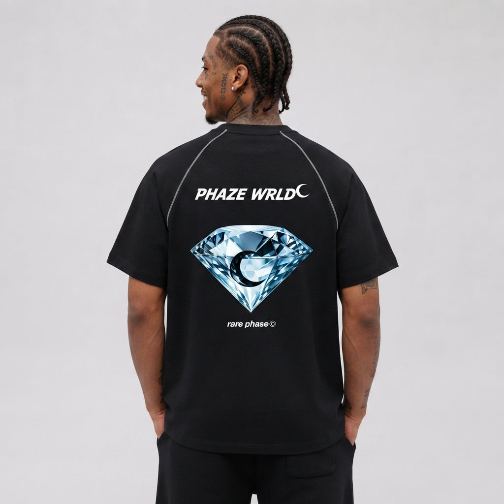 Back view of a premium black raglan streetwear t-shirt with white contrast stitching, a large blue diamond graphic, and white brand lettering.
