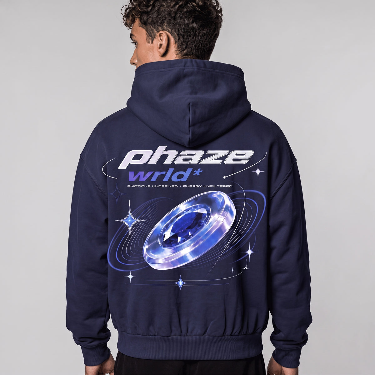 Back view of a model wearing the navy Blue Frequency hoodie, showing the large 'phaze wrld*' cosmic gem graphic.