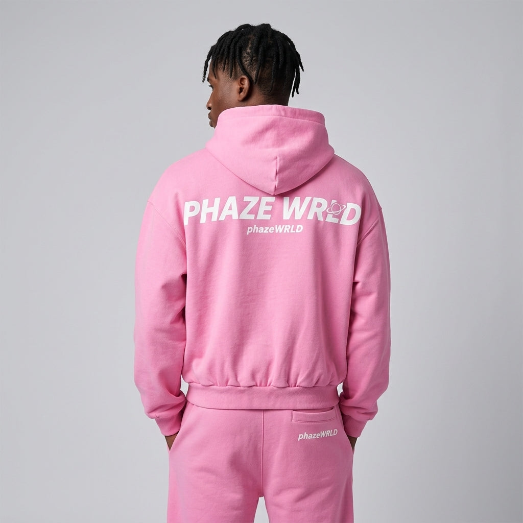 Back view of a premium bubblegum pink oversized streetwear hoodie featuring white graphic text spelling Phaze Wrld on heavyweight fleece.
