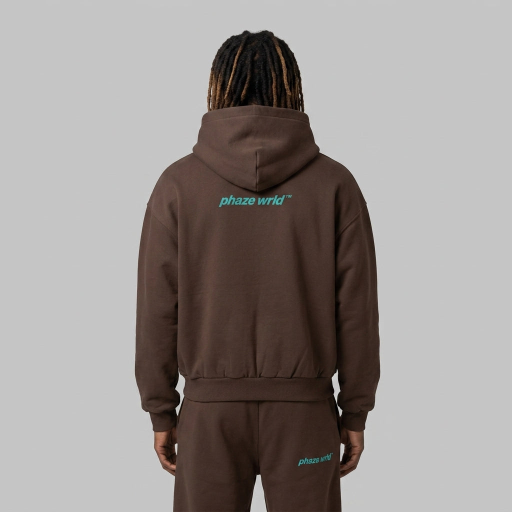 Back view of a premium chocolate brown oversized cropped streetwear hoodie featuring a small teal phaze wrld logo on the upper back.