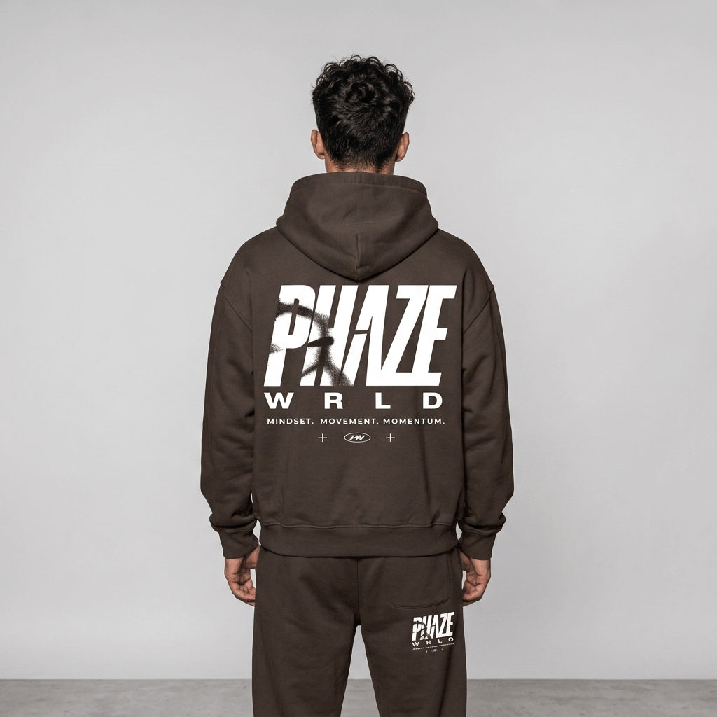 Back view of a premium heavyweight chocolate brown oversized streetwear hoodie featuring a bold white PHAZE WRLD graphic print.
