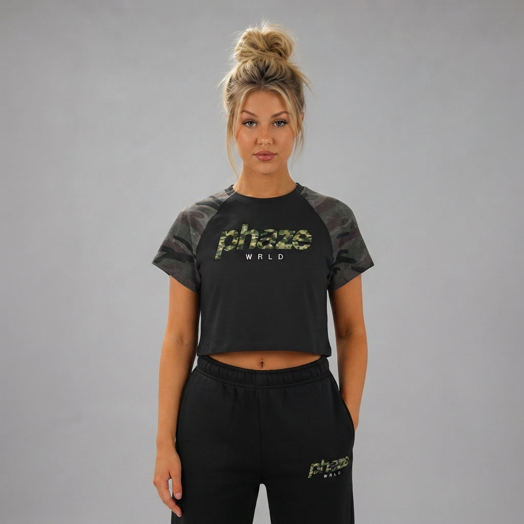 A cropped black raglan baby tee featuring dark woodland camouflage sleeves and a matching camo phaze wrld graphic on the chest.
