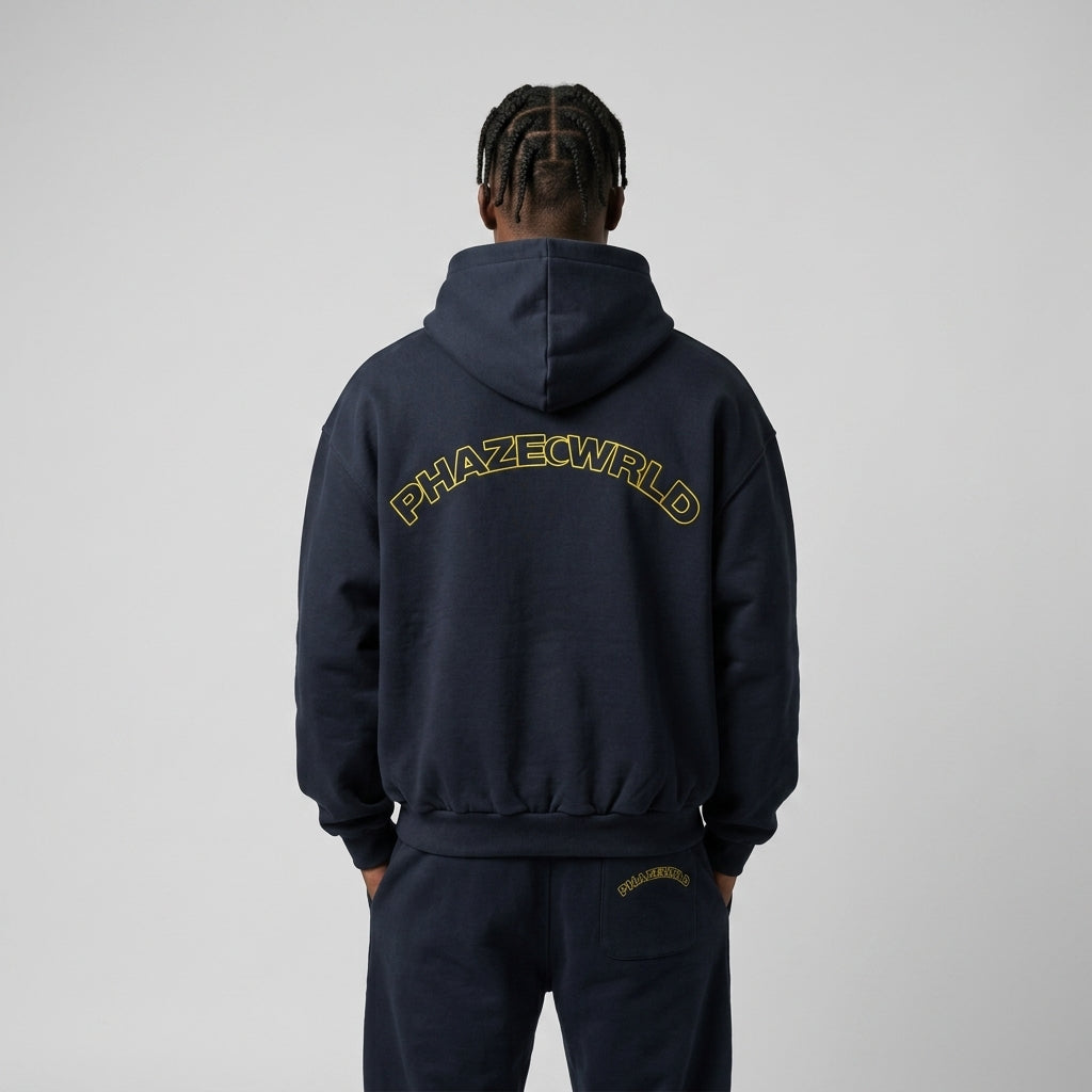 Back view of a premium dark navy oversized streetwear hoodie featuring a yellow outlined arched PHAZEWRLD logo on the upper back.