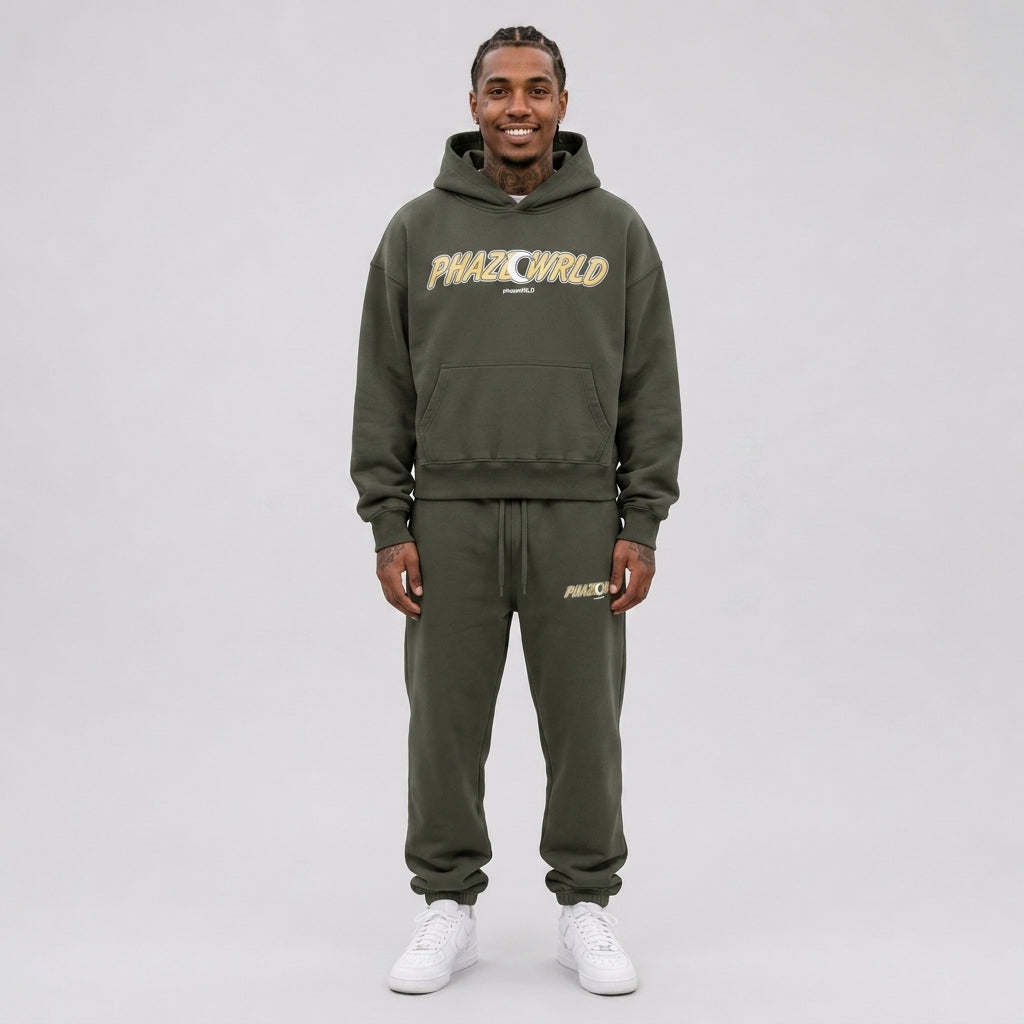 An oversized cropped streetwear hoodie in dark olive green, featuring a heavyweight cotton fleece build and a yellow and white graphic print.