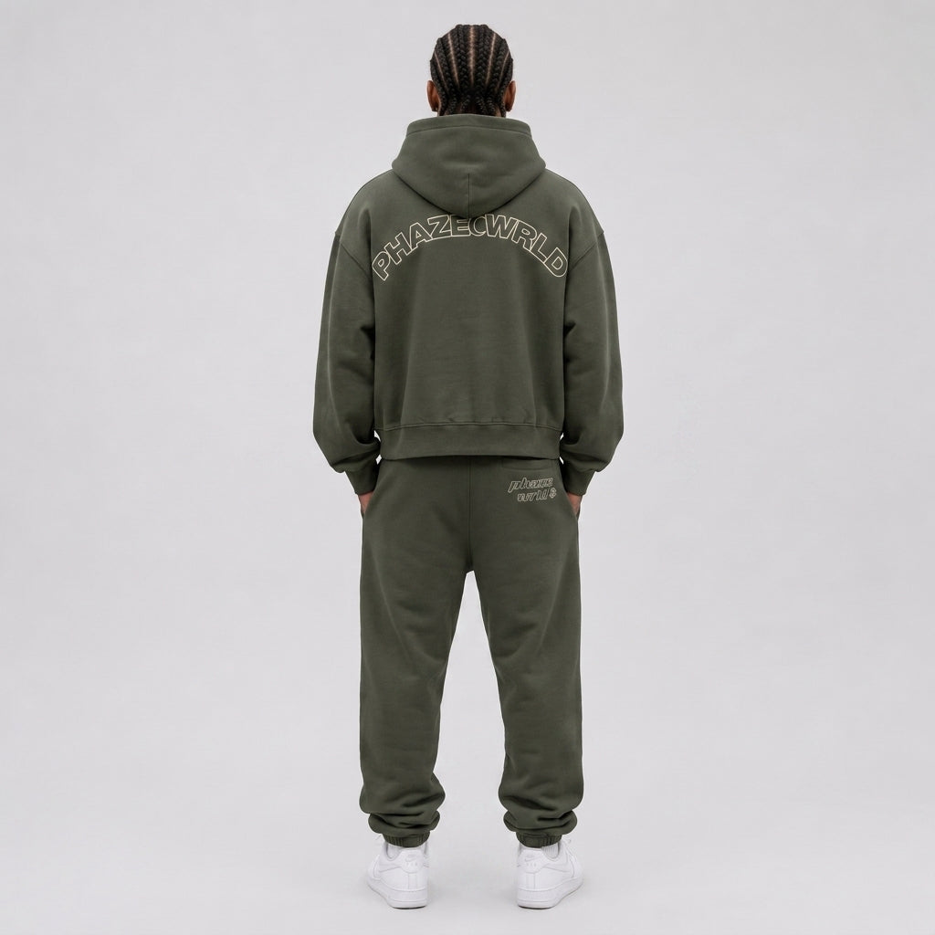 A premium oversized dark olive green streetwear hoodie with a oversized fit and cream arched PHAZEWRLD outline wordmark across the back.