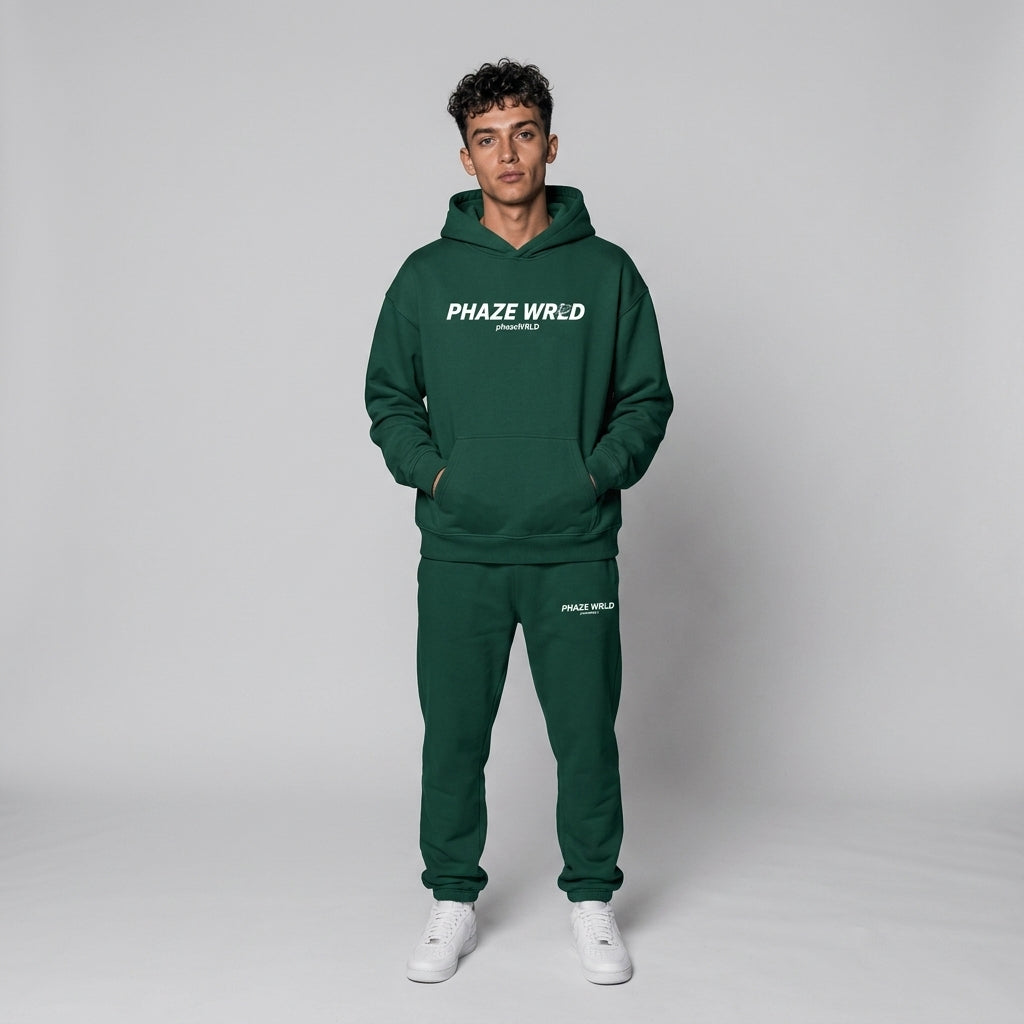 A premium forest green oversized streetwear hoodie featuring a bold white graphic on the chest, dropped shoulders, and a kangaroo pocket.