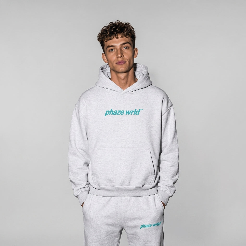 A premium light heather grey oversized streetwear hoodie featuring a cropped fit, dropped shoulders, and a vibrant teal 'phaze wrld' chest logo.