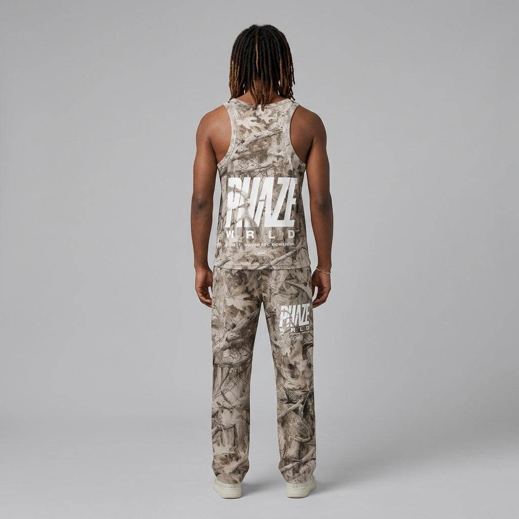 A premium streetwear racerback tank top in a muted beige oak leaf camouflage pattern with a bold white PHAZE WRLD graphic on the chest.