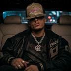 Model wearing the Multicam Arid/Brown Trucker Cap, front view showing the pink 'PHAZE WRLD' text and brown mesh back.