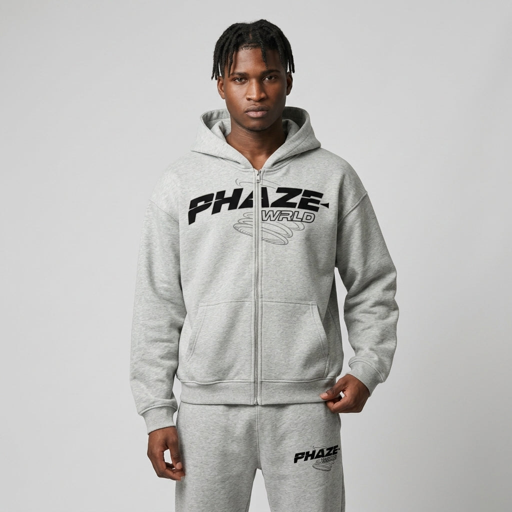 Oversized heather grey streetwear zip-up hoodie featuring a bold black PHAZE WRLD graphic print and a classic boxy fit.