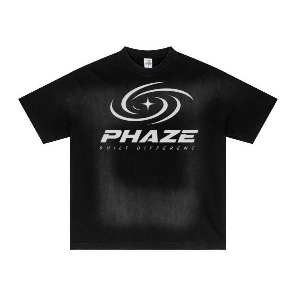 Black streetwear oversized t-shirt featuring a futuristic silver PHAZE swirl graphic and "Built Different" text. Heavyweight cotton boxy fit.
