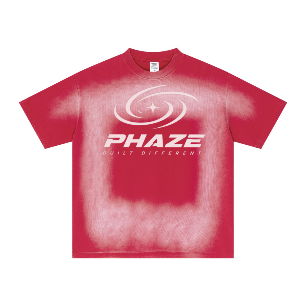 Red streetwear oversized t-shirt featuring a futuristic silver PHAZE swirl graphic and "Built Different" text. Heavyweight cotton boxy fit.