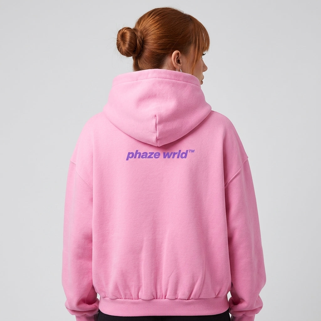 Back view of a premium bubblegum pink oversized streetwear hoodie featuring a small purple printed back graphic and cinched ribbed waist.