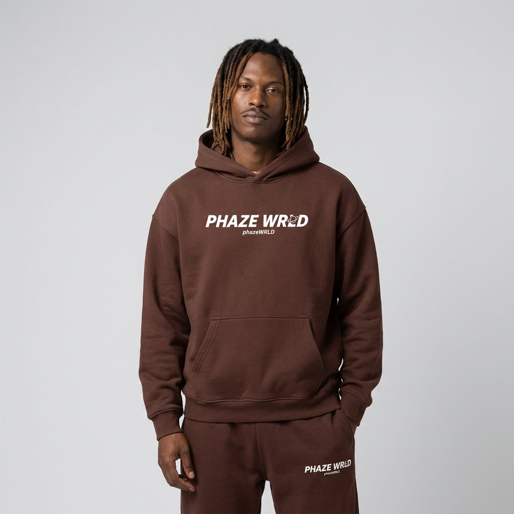 Premium chocolate brown oversized streetwear hoodie featuring a minimalist white chest graphic and relaxed drop-shoulder fit.