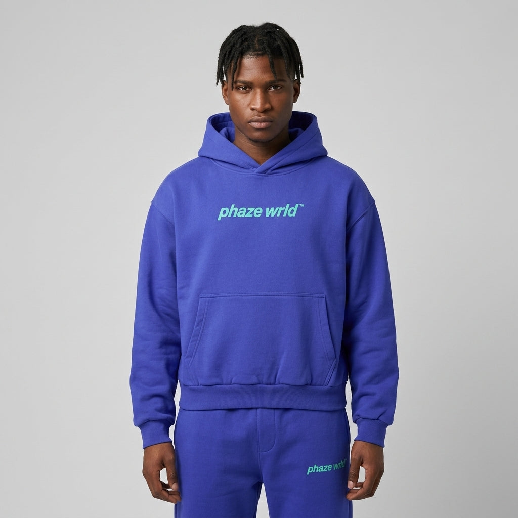 A premium cobalt blue oversized streetwear hoodie featuring a mint green phaze wrld chest logo, dropped shoulders, and a boxy cropped fit.