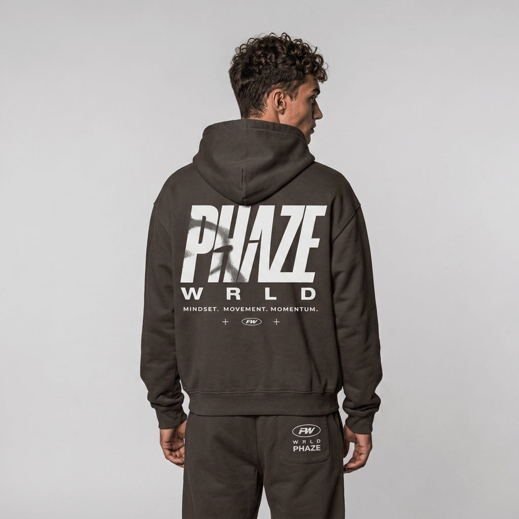 Back view of a premium espresso brown oversized streetwear hoodie featuring a bold white Phaze Wrld graphic print on heavyweight fleece.