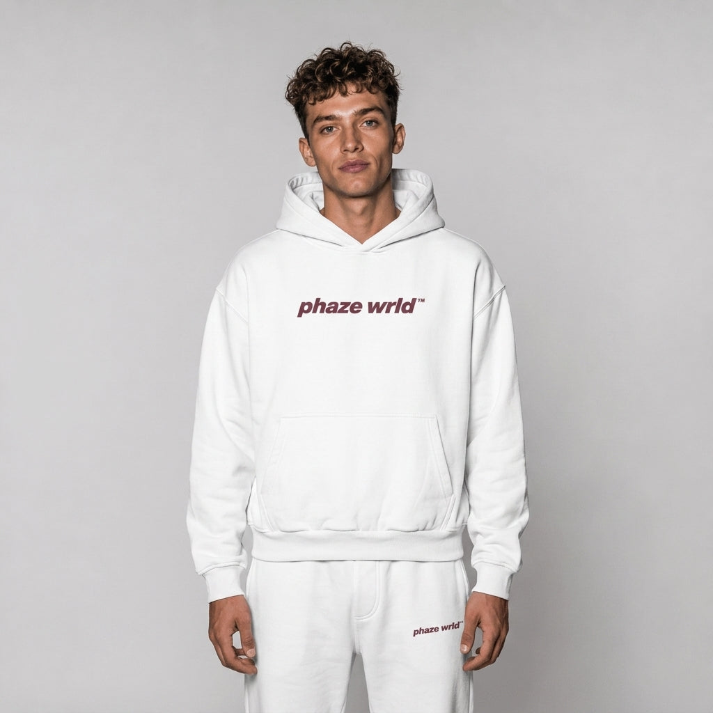 A studio lookbook photo of a premium optic white oversized streetwear hoodie featuring a plum-colored phaze wrld chest graphic.