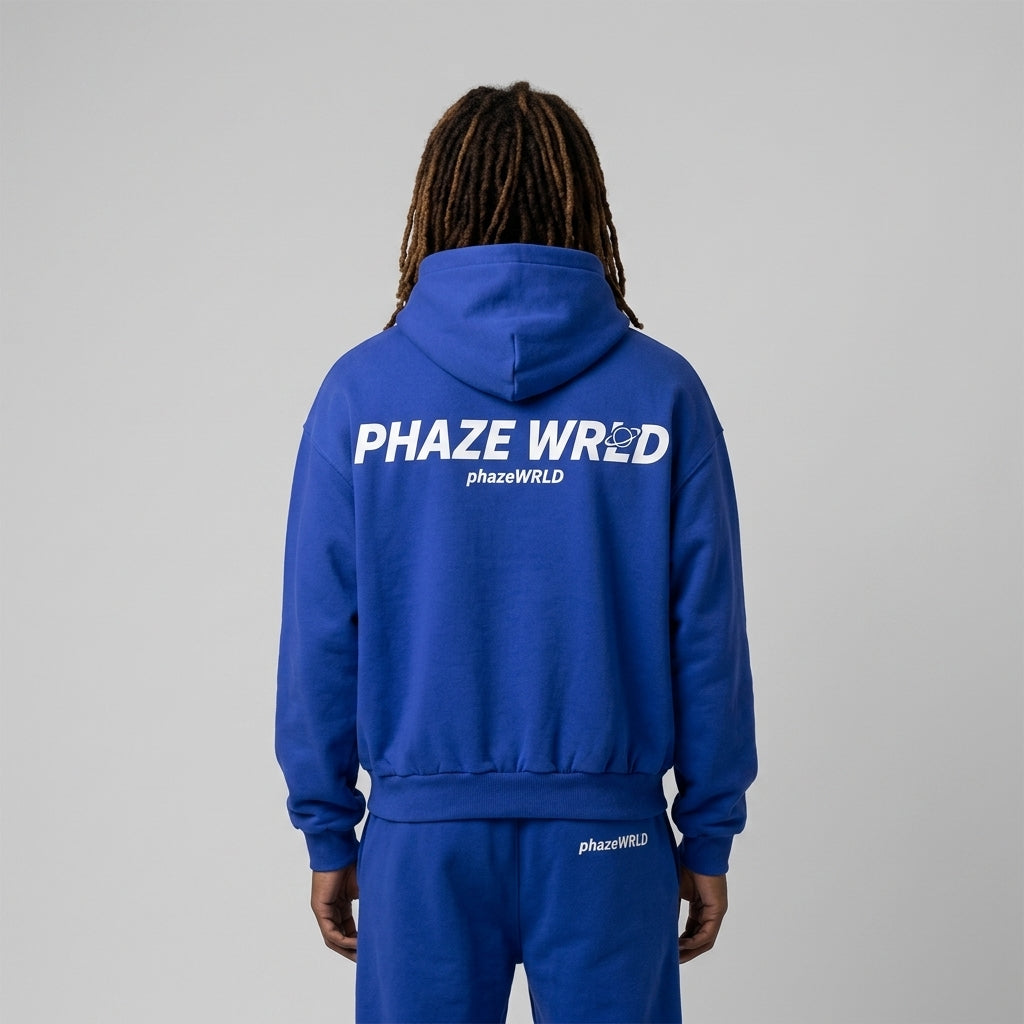 Back view of a premium royal blue oversized streetwear hoodie featuring a white Phaze Wrld italic graphic and a custom planet Saturn logo.